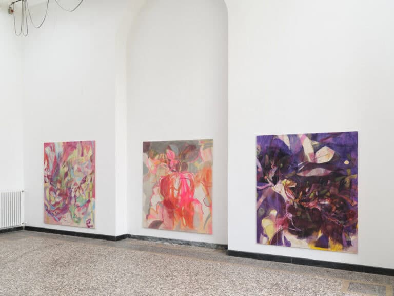 Foto: Aufnahme eines Ausstellungsraum mit drei großformatigen bunten Gemälde an den Wänden.