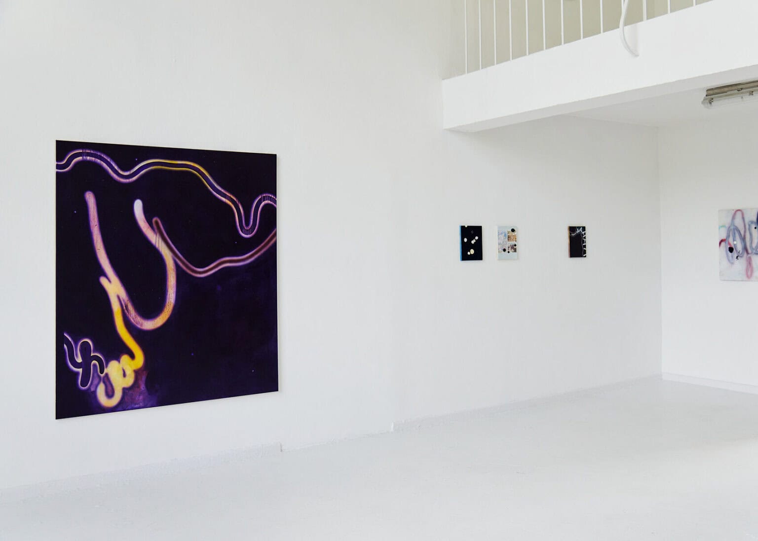 Foto: Ein Raum mit weißen Wänden und weißem Boden. An den Wänd hängen groß- und kleinformatige Leinwandarbeiten.