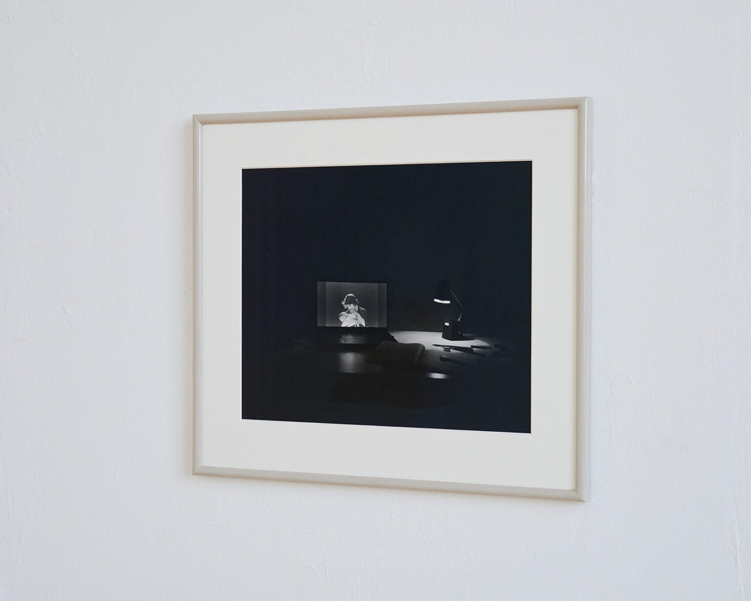 Foto: Nahaufnahme eines gerahmten Objektes vor weißer Wand.