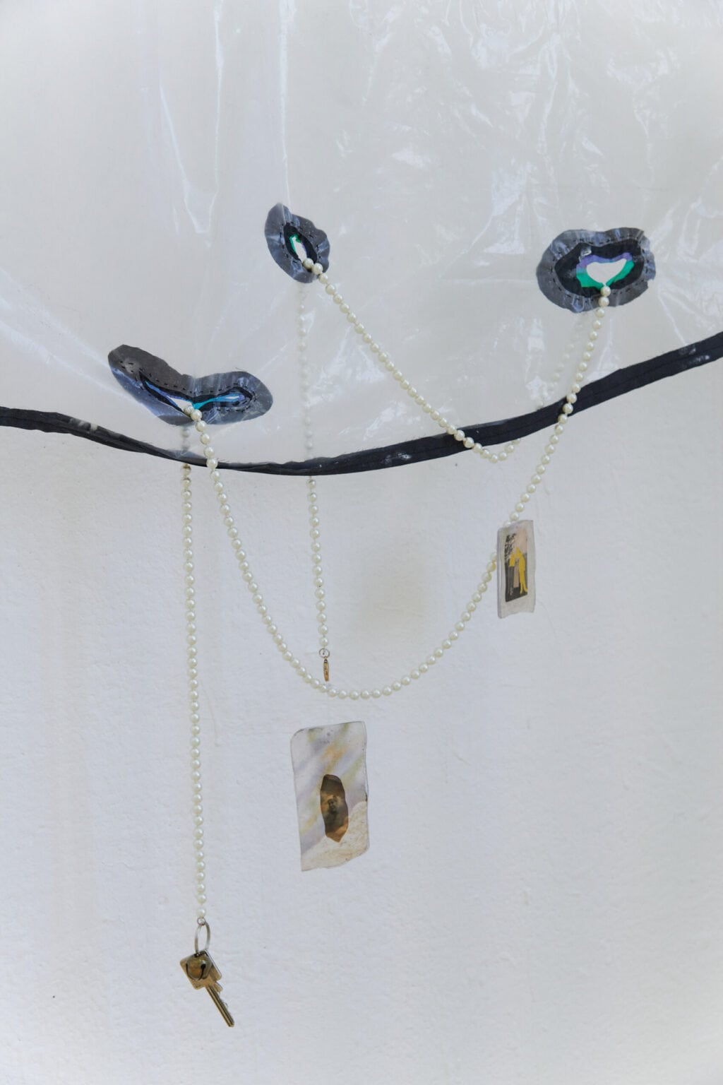 Foto: Nahaufnahme eines Objektes aus unterschiedlichen Materialien vor weißer Wand.