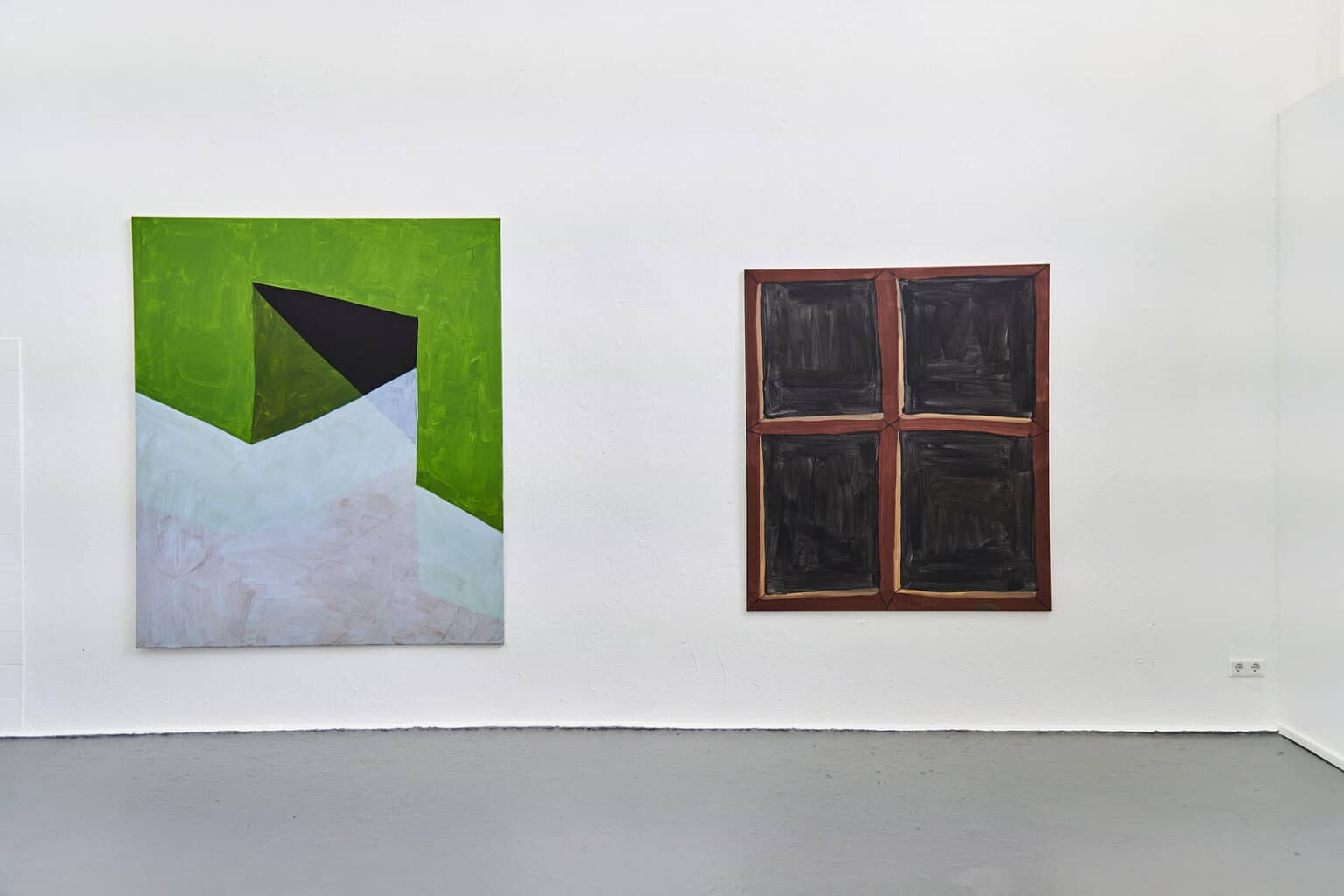 Foto: Ein Raum mit weißen Wänden und grauem Boden. An einer der Wände hängen zwei großformatige Leinwände.