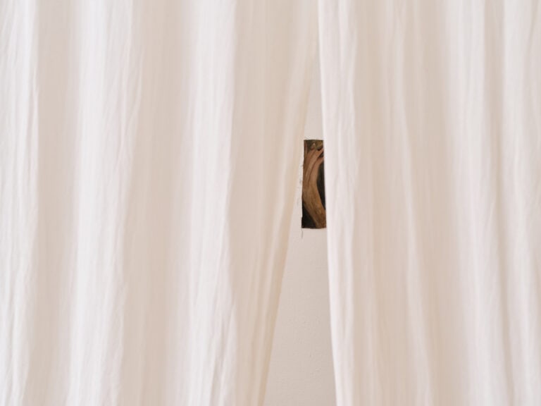 Foto: Detailaufnahme eines Gemäldes, das hinter Tüchern versteckt ist.