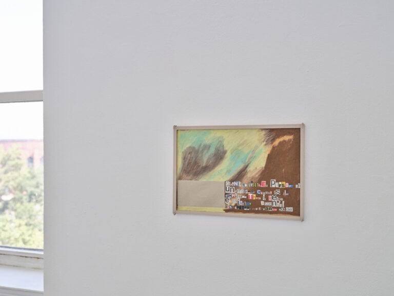 Foto: Detailaufnahme eines Kunstwerks auf einer weißen Wand. Am linken Rand ist ein Fenster zu erkennen.