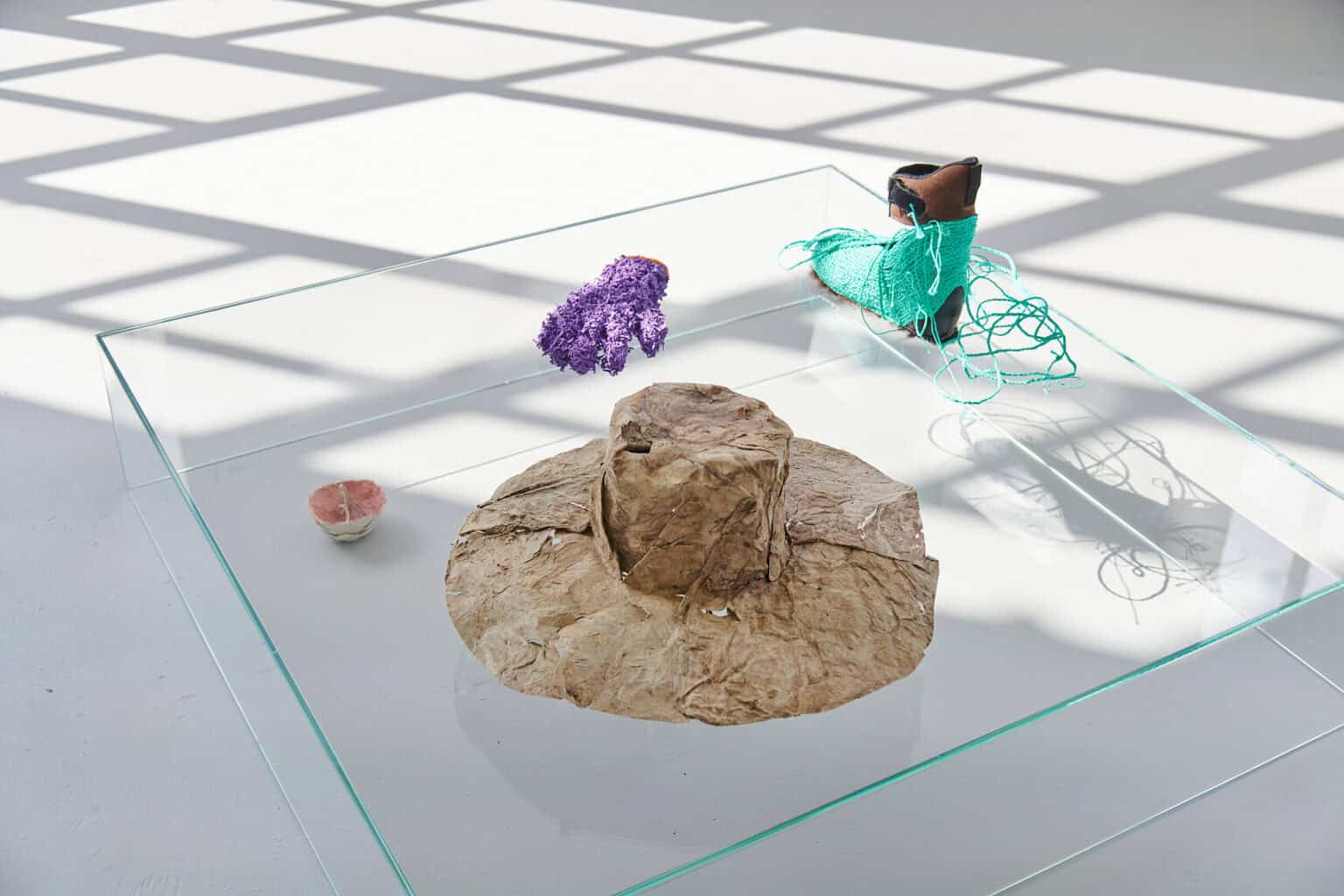 Foto: Eine Gruppe von Objekten aus unterschiedlichen Materialien auf grauem Boden.