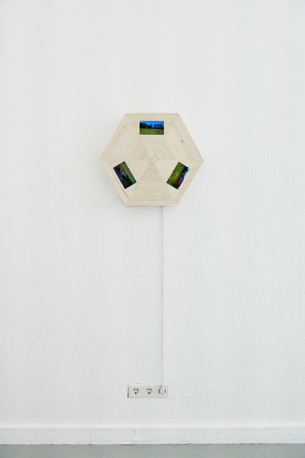 Foto: Ein mit einer Steckdose verkabeltes Objekt vor weißer Wand.