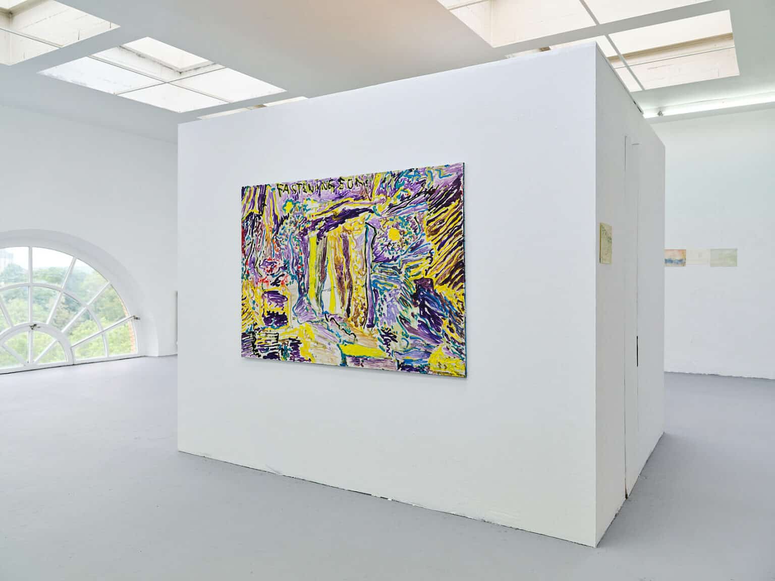 Foto: Ansicht eines Raumes mit weißen Wänden, grauem Boden, einem kleinen Bogen- und Deckenfenstern. Im Raum befindet sich ein großer weißer Kubus, auf dem eine mittelformatige Malerei hängt.