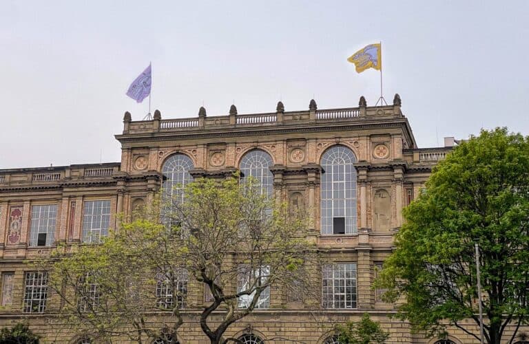 Foto: Außenansicht historisches Gebäude mit zwei Flaggen auf dem Dach