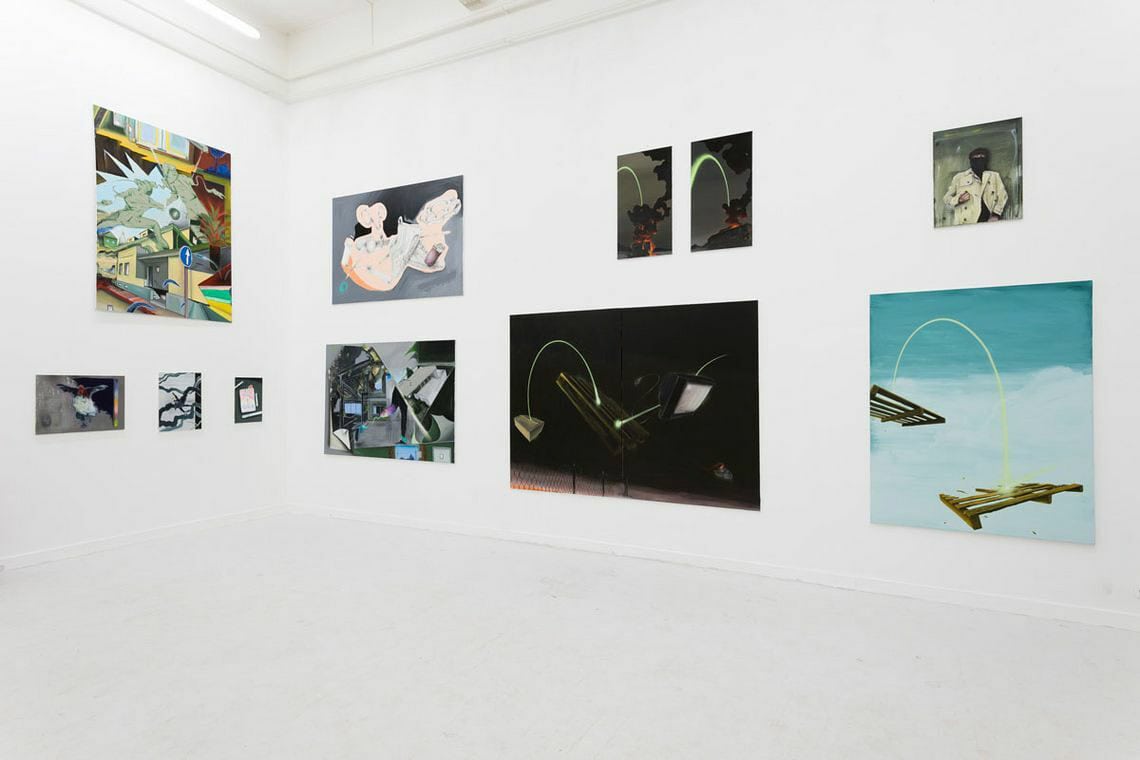 Foto: Ein Raum mit weißen Wänden und hellgrauem Boden. An den Wänden hängen, neben und übereinander, Leinwände in unterschiedlichen Formaten.