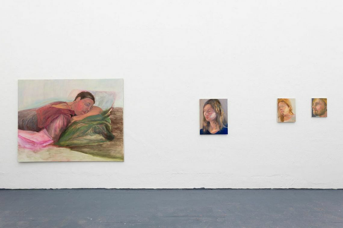 Foto: Ein Raum mit weißen Wänden und grauem Boden. An der Wand Leinwandarbeiten in unterschiedlichen Formaten.