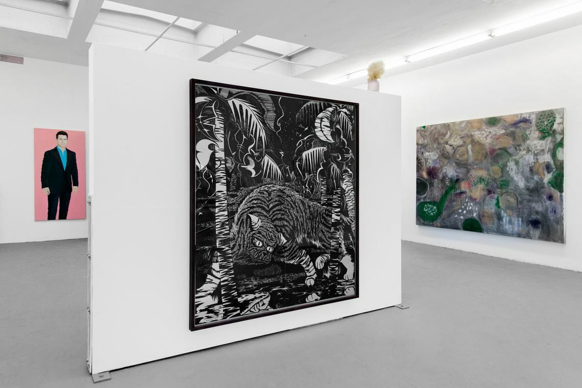 Foto: Ein Raum mit weißen Wänden, grauem Boden und einer eingezogenen Wand. Im Raum befinden sich mehrere großformatige Leinwandarbeiten.