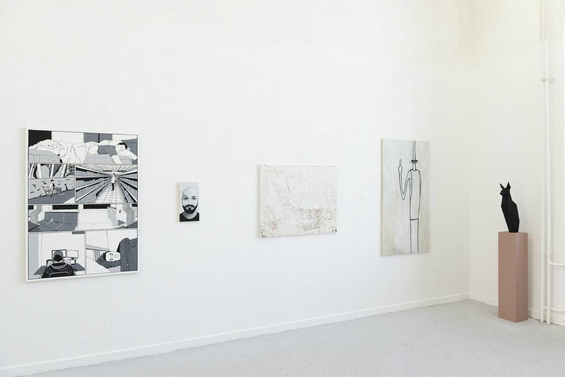Foto: Ein Raum mit weißen Wänden und grauem Boden. An den Wänden hängen Leinwandarbeiten im Klein- und Mittelformat nebeneinander. Vor einer der Wände steht eine Skulptur auf einem Sockel.