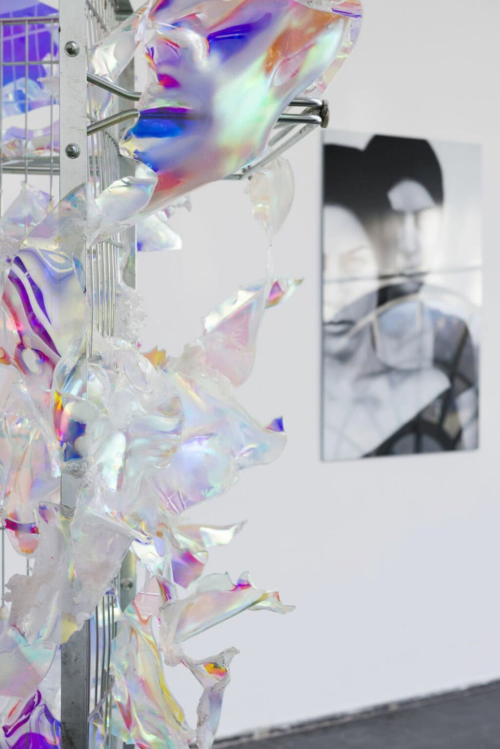 Foto: Ein Raum mit weißen Wänden. An der Wand und im Raum befinden sich Objekte, eines von ihnen besteht unter anderem aus einem reflektierendem, schimmernden Material.