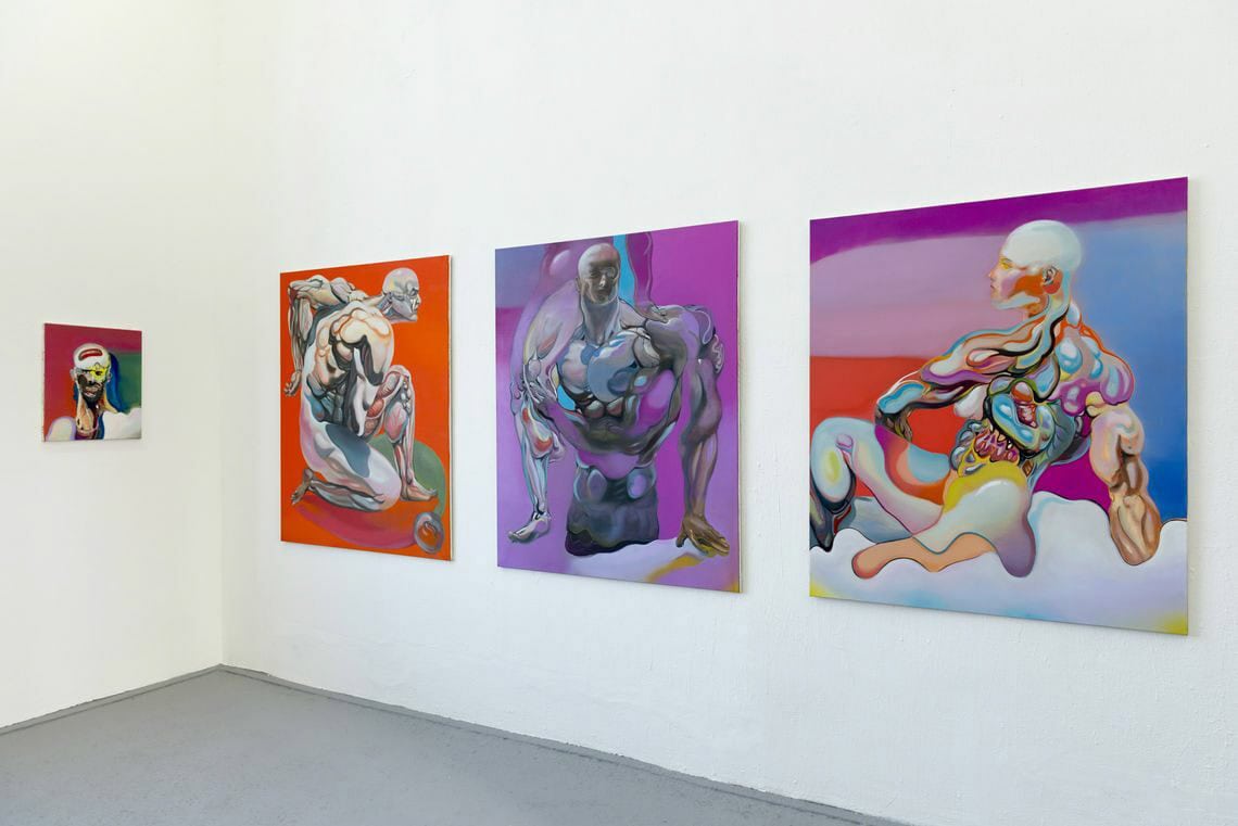 Foto: Ein Raum mit weißen Wänden und grauem Boden. An der Wand befinden sich mehrere Leinwandarbeiten im Klein- und Mittelformat auf gleicher Mittellinie.